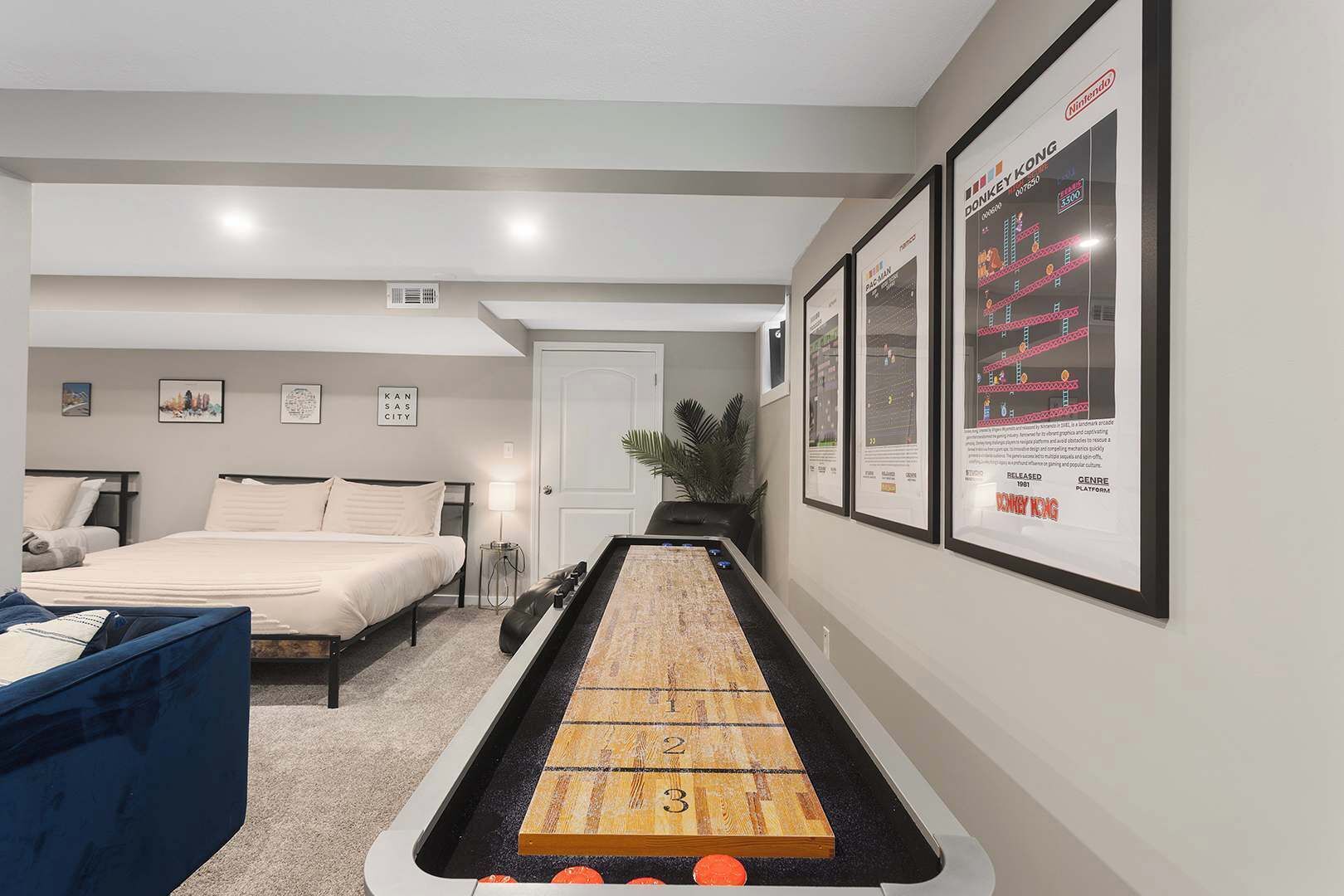 A modern hotel room with a bed, a desk, and a shuffleboard table.