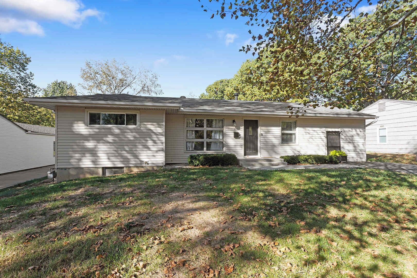 A single-story house with a front porch, a garage, and a small front yard.