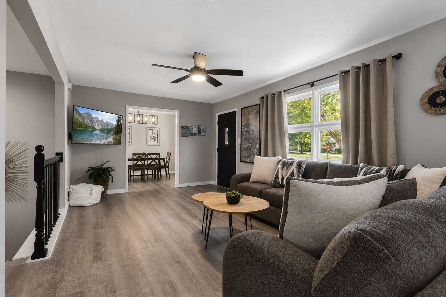 A modern living room with a sofa, a coffee table, and a dining area with chairs.
