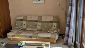 A cozy living room with a wooden sofa, a coffee table with plants, and a painting on the wall. - Spacious studio for rent, Orcières ski center (Orcières Merlette)