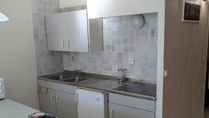 A compact kitchen with a double sink, a small refrigerator, and a kettle on the counter. - Spacious studio for rent, Orcières ski center (Orcières Merlette)
