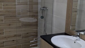A modern bathroom with a wooden wall backsplash, a white sink, and a glass shower enclosure. - Spacious studio for rent, Orcières ski center (Orcières Merlette)