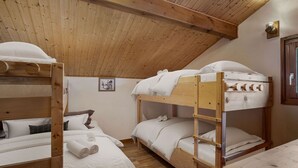 Een gezellige, houten inrichting met een slaapzaal met stapelbedden, een kleine tafel en een lijst met een foto aan de muur.