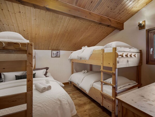 A cozy, wooden-furnished dormitory room with bunk beds, a small table, and a framed picture on the wall. - Savoyard chalet near slopes, 13 guests, Parking, Wifi (La Tania)