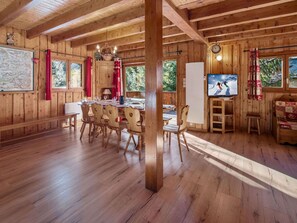 A wooden cabin interior with a dining area, a TV, and a large window. - Savoyard chalet near slopes, 13 guests, Parking, Wifi (La Tania)
