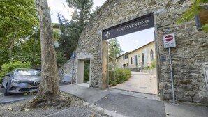 En byggnad av sten med en skylt som visar texten ”IL CONVENTINO FUORI LE MURA” och en skylt som förbjuder inträde.