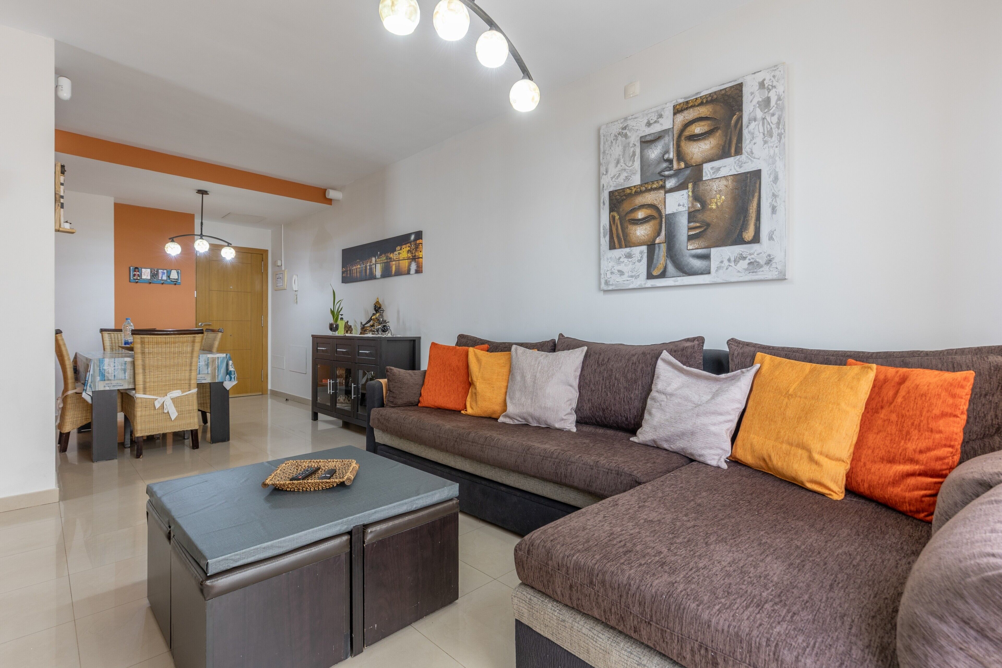 Een woonkamer met een bank, een salontafel en een eethoek met stoelen en een tafel.