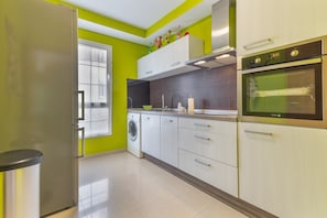 Una cocina equipada con lavadora, refrigerador y microondas.