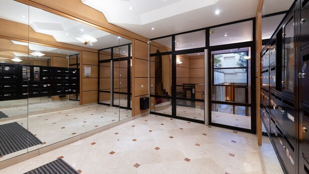 A modern hotel lobby with a glass partition, a reception desk, and a storage area with filing cabinets. - Parc Monceau - Villiers - Studio (Paris)