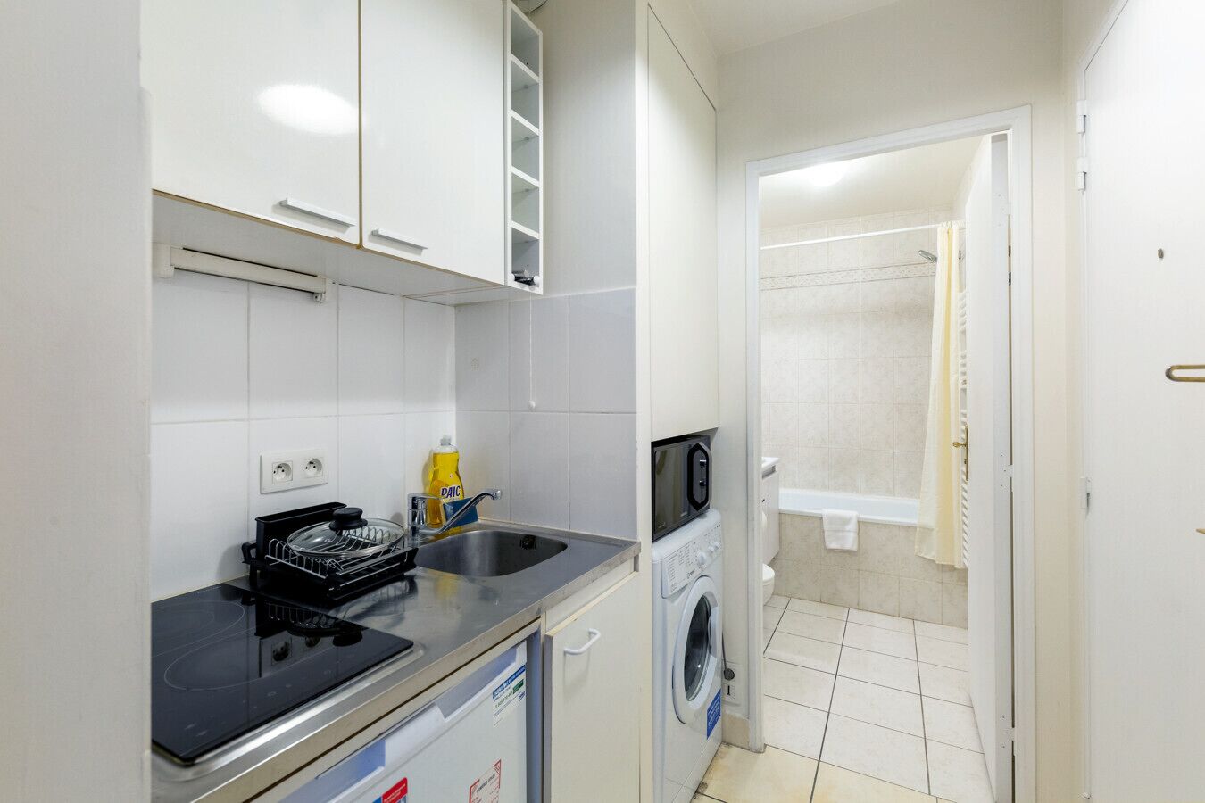 A compact kitchen with a microwave, sink, and dishwasher.