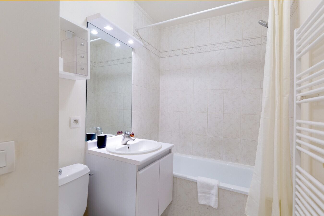 A bathroom with a white sink, mirror, and shower area.