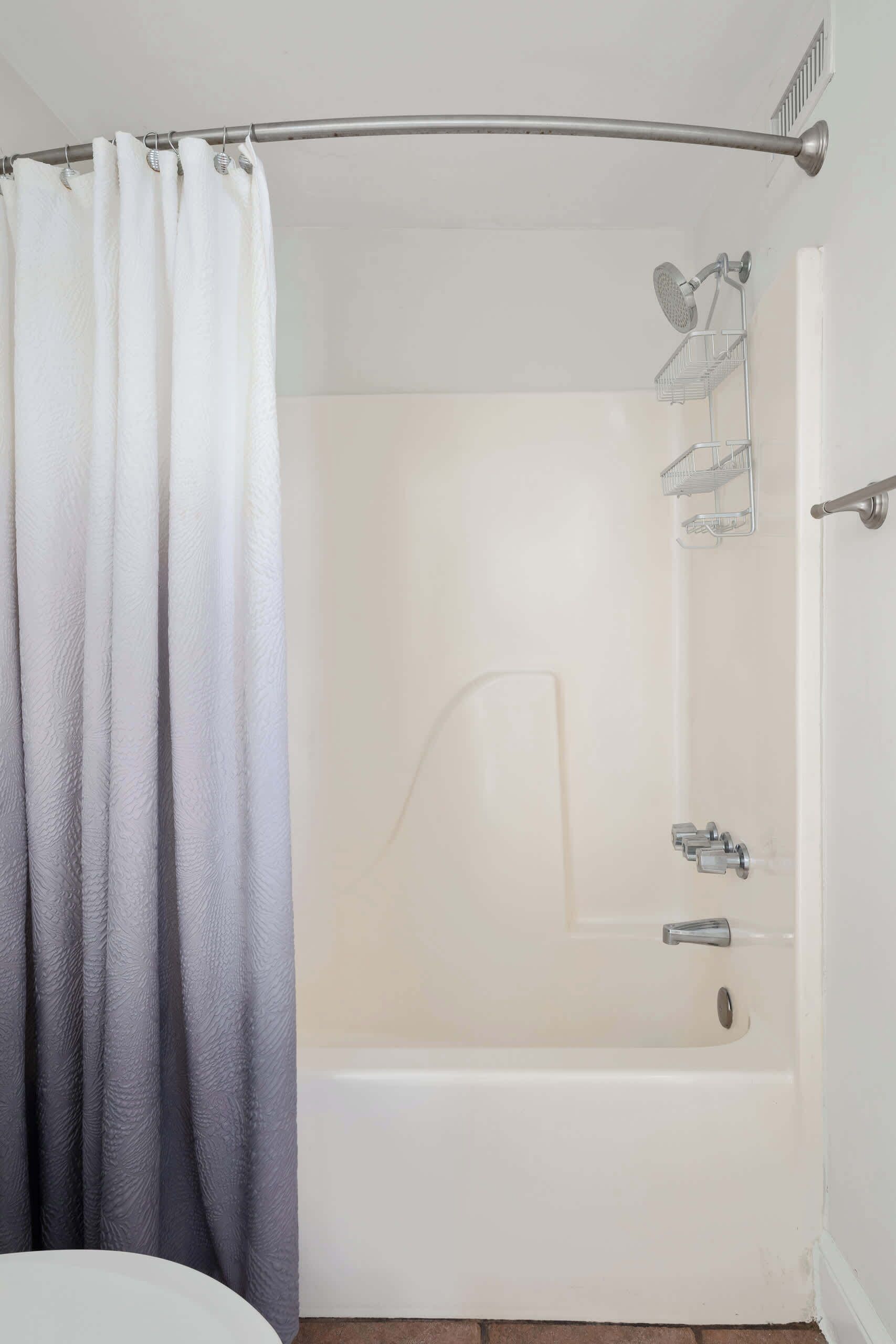 Un baño con bañera, ducha e inodoro.
