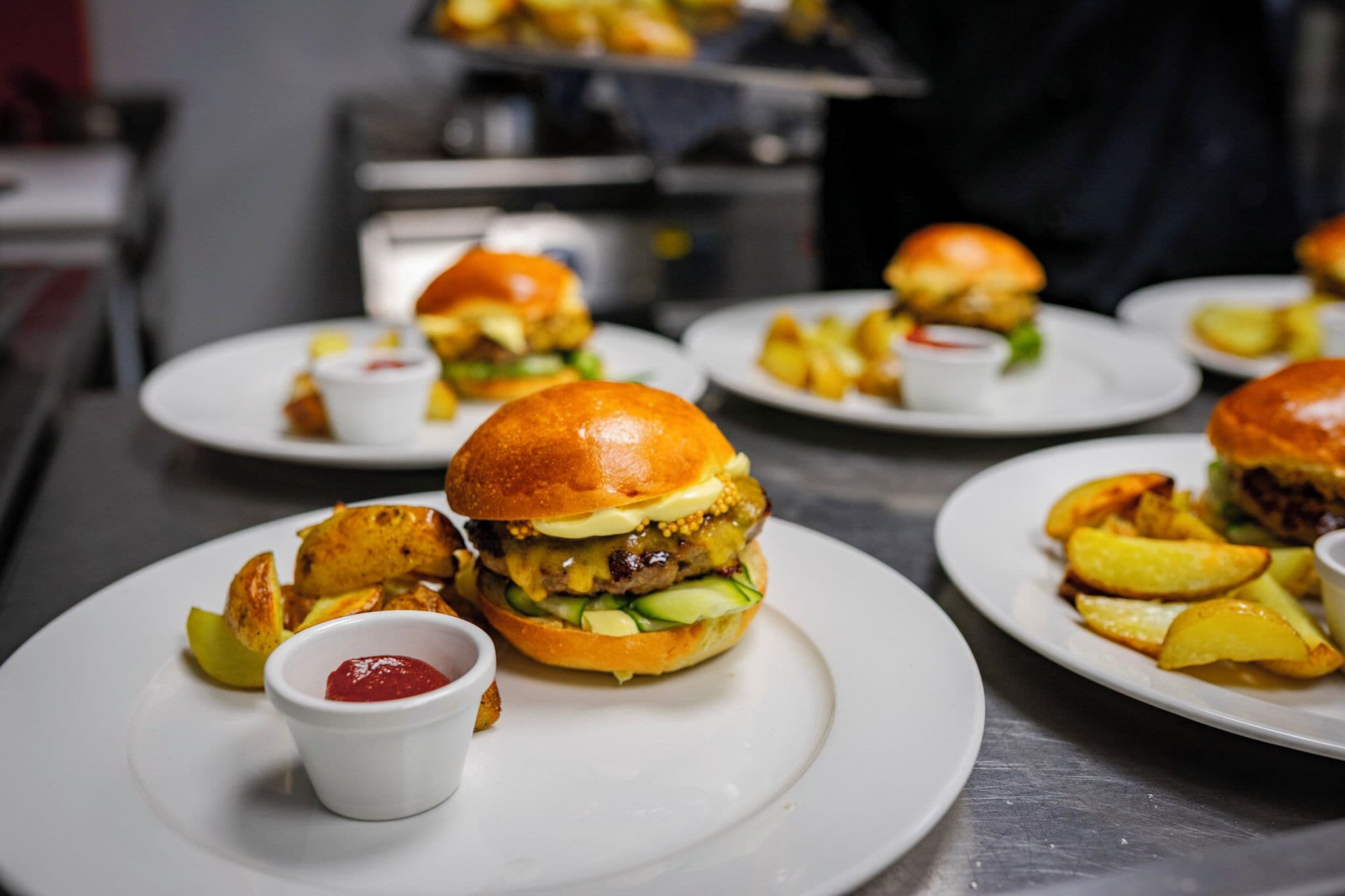 Een restaurantscène met verschillende borden burgers en friet.