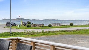 Une zone côtière comprenant un parking, un drapeau et un banc.