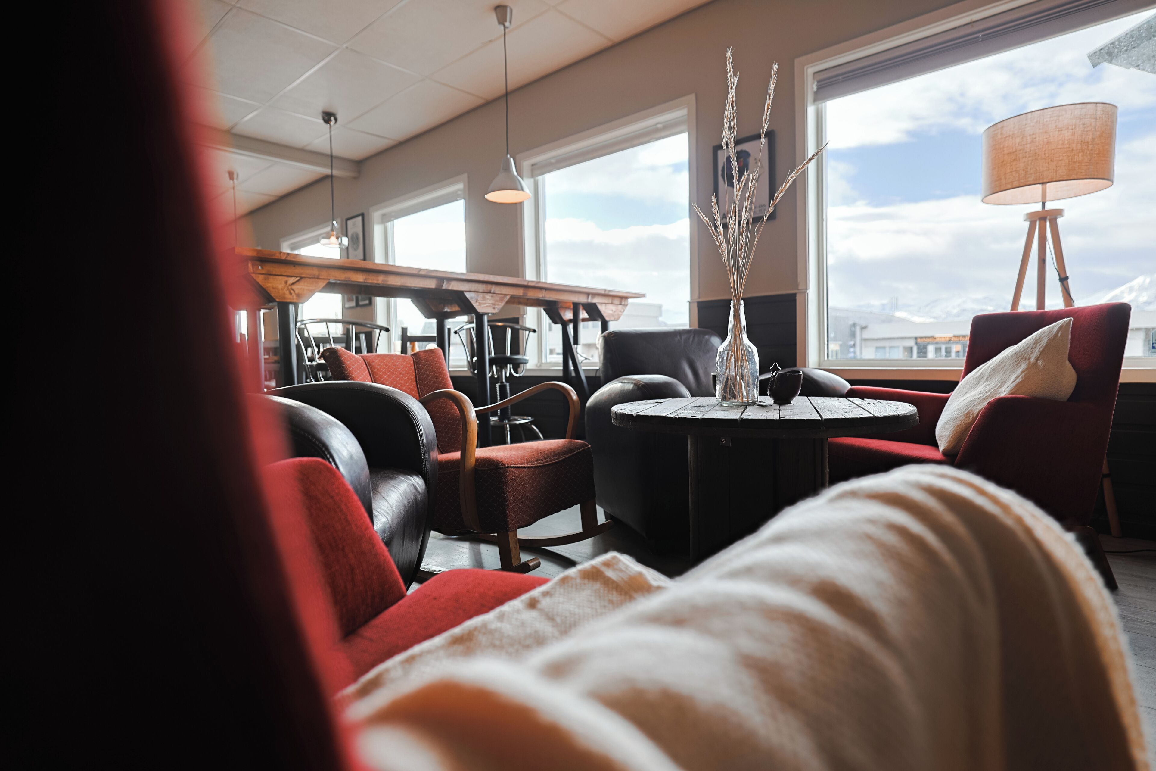 Un interior moderno con comedor, asientos y vistas amplias a través de grandes ventanales.