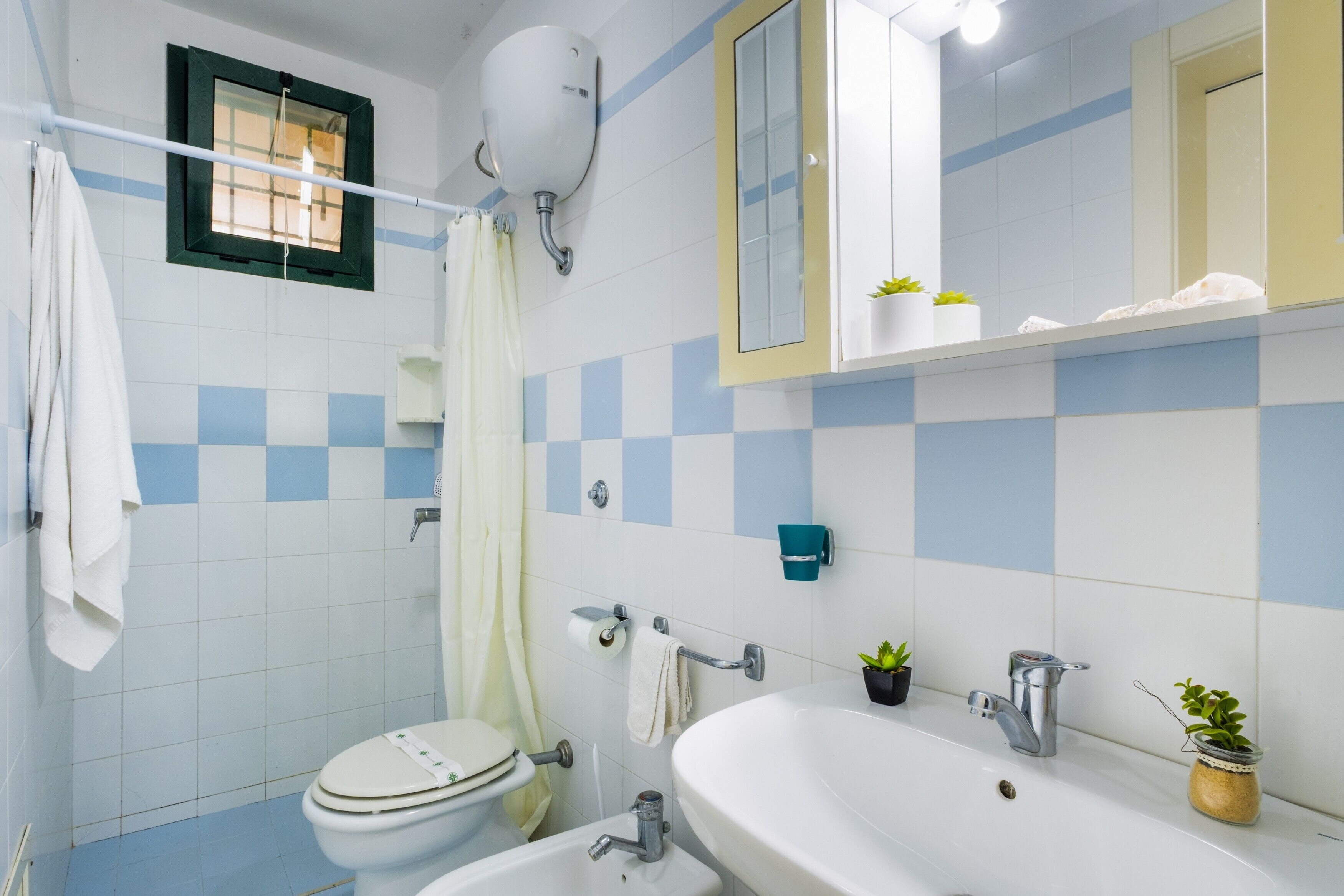 Ein Badezimmer mit Toilette, Waschbecken und Duschbereich.