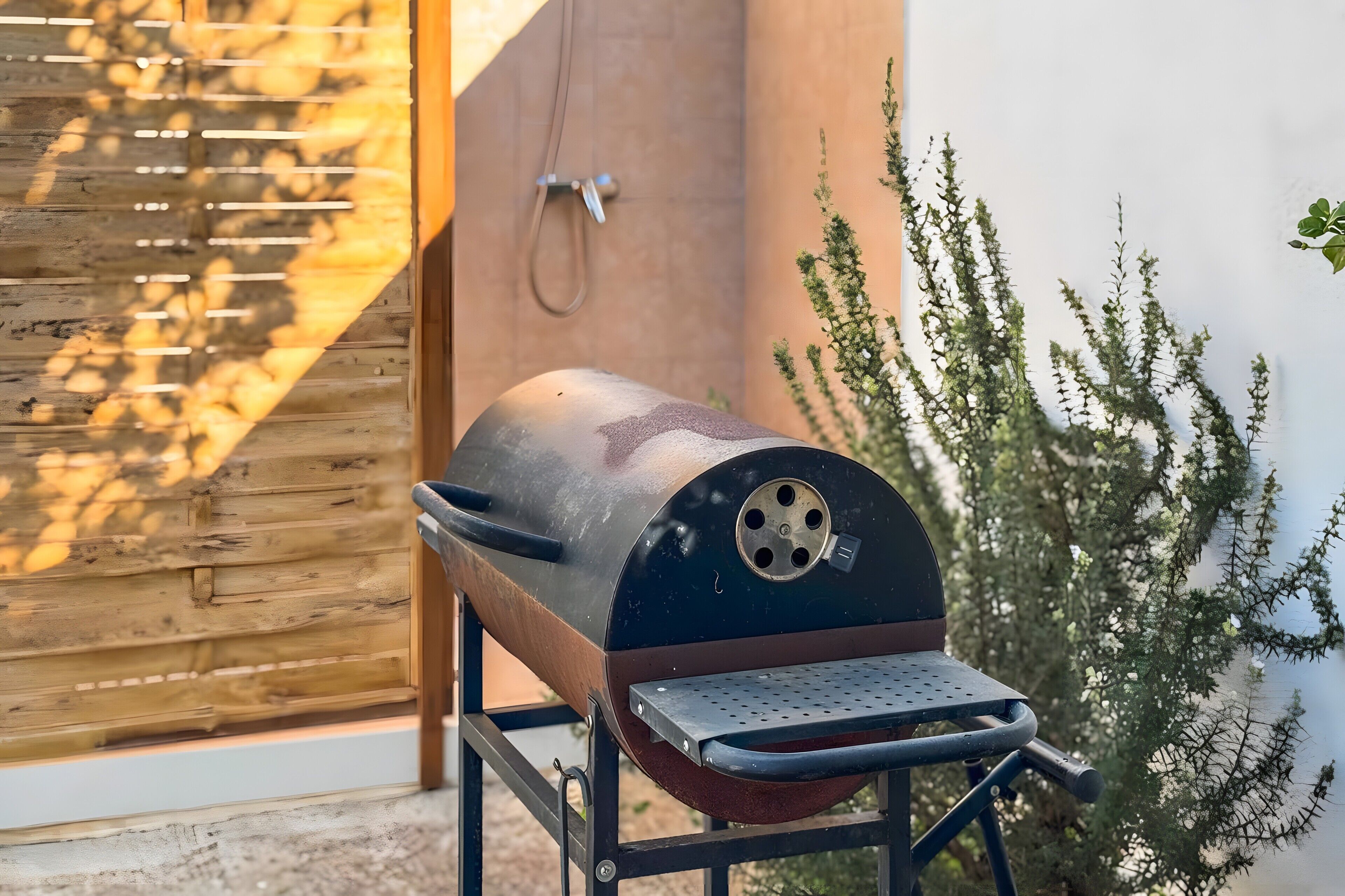 Una griglia barbecue con una griglia metallica, un tubo e un supporto in metallo.