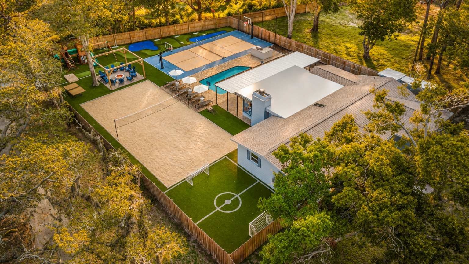 Ett mångsidigt utomhusområde med en basketplan, en pool och en uteplats med sittplatser.