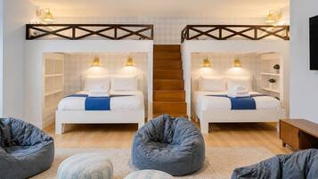 A bedroom with two beds, a ceiling fan, and a staircase.