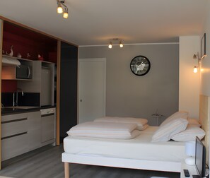 Un dormitorio moderno con cama, mesita de noche y un reloj de pared.