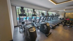 A gym with treadmills, elliptical machines, and free weights.