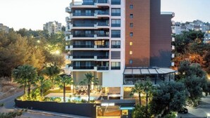 A multi-story hotel with balconies, a rooftop terrace, and a sign reading "UTOPIA SUITE".