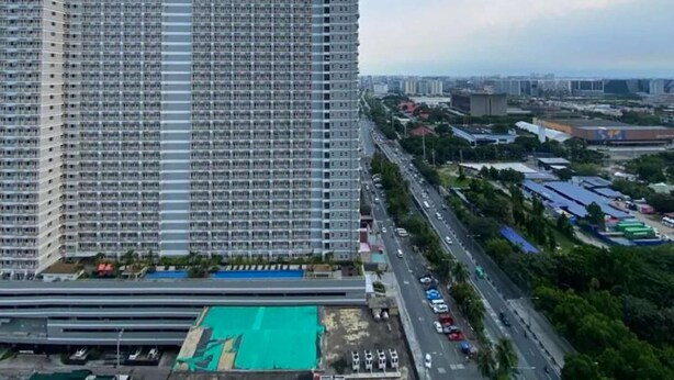 Un immeuble de grande hauteur doté d’une façade plate et d’un espace de stationnement sur le toit.