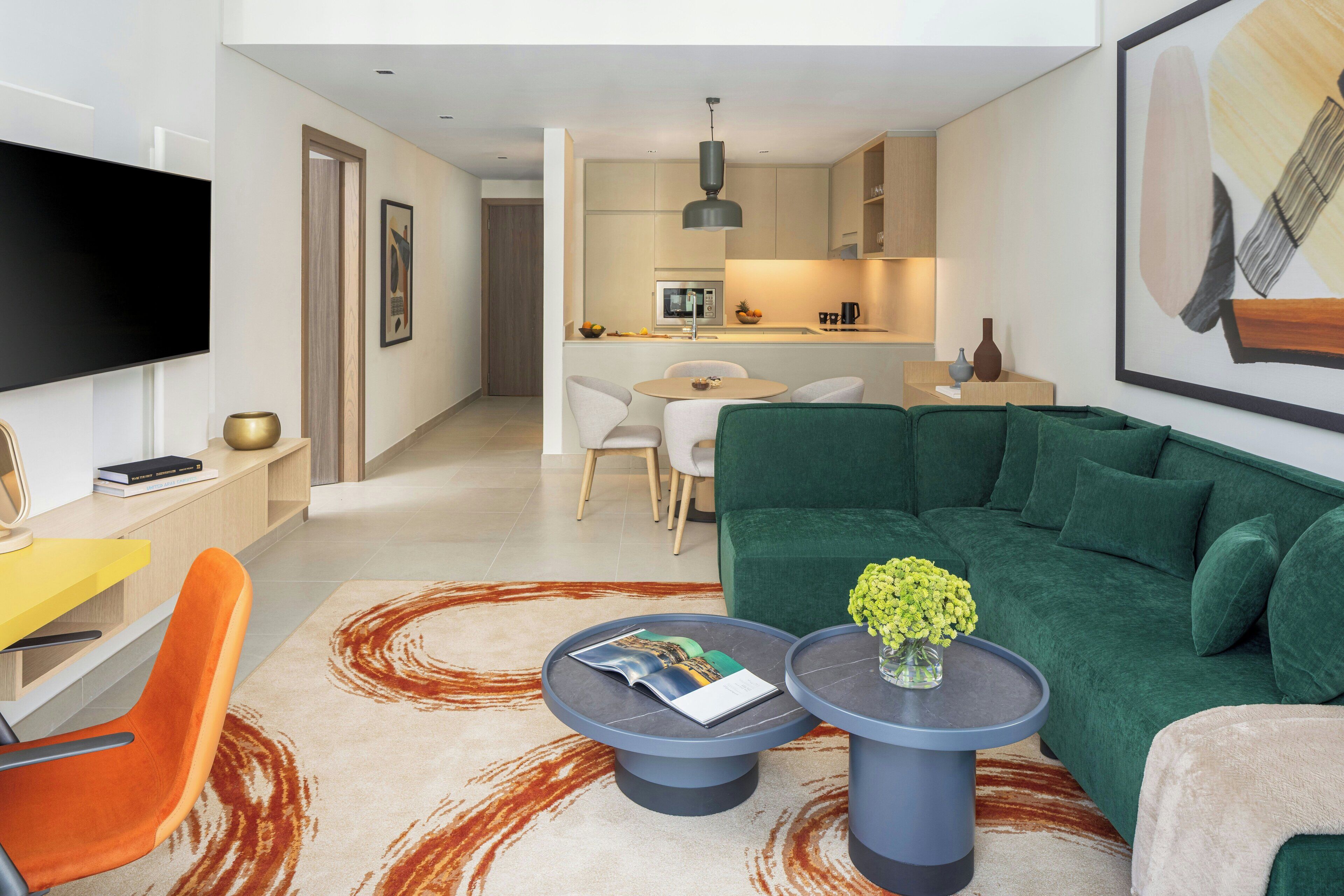 A modern living room with a green sofa, a coffee table, and a TV.