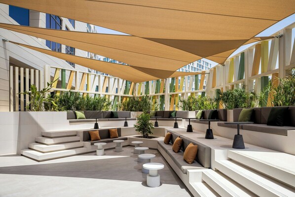 An outdoor seating area with tiered steps, cushioned seating, and tables.