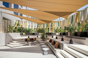Un espacio al aire libre con escalones escalonados, asientos acolchados y mesas.