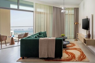 Una sala de estar moderna con un sofá verde, una mesa de centro y vistas de la ciudad.