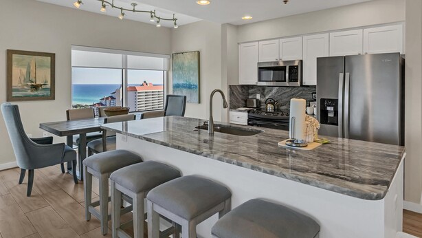 A modern kitchen with a large island, stainless steel appliances, and a view of the ocean. - Inviting 2 Bedroom Condo – SanDestin Golf and Beach Resort (Miramar Beach)