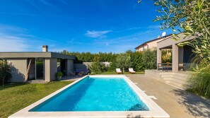 A rectangular swimming pool with a clear blue water surface, surrounded by a paved deck. - Vila PrivePolai by Villas Guide (Pula)