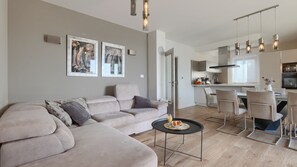 A modern living room with a sofa, a coffee table, and a dining area with chairs. - Vila PrivePolai by Villas Guide (Pula)