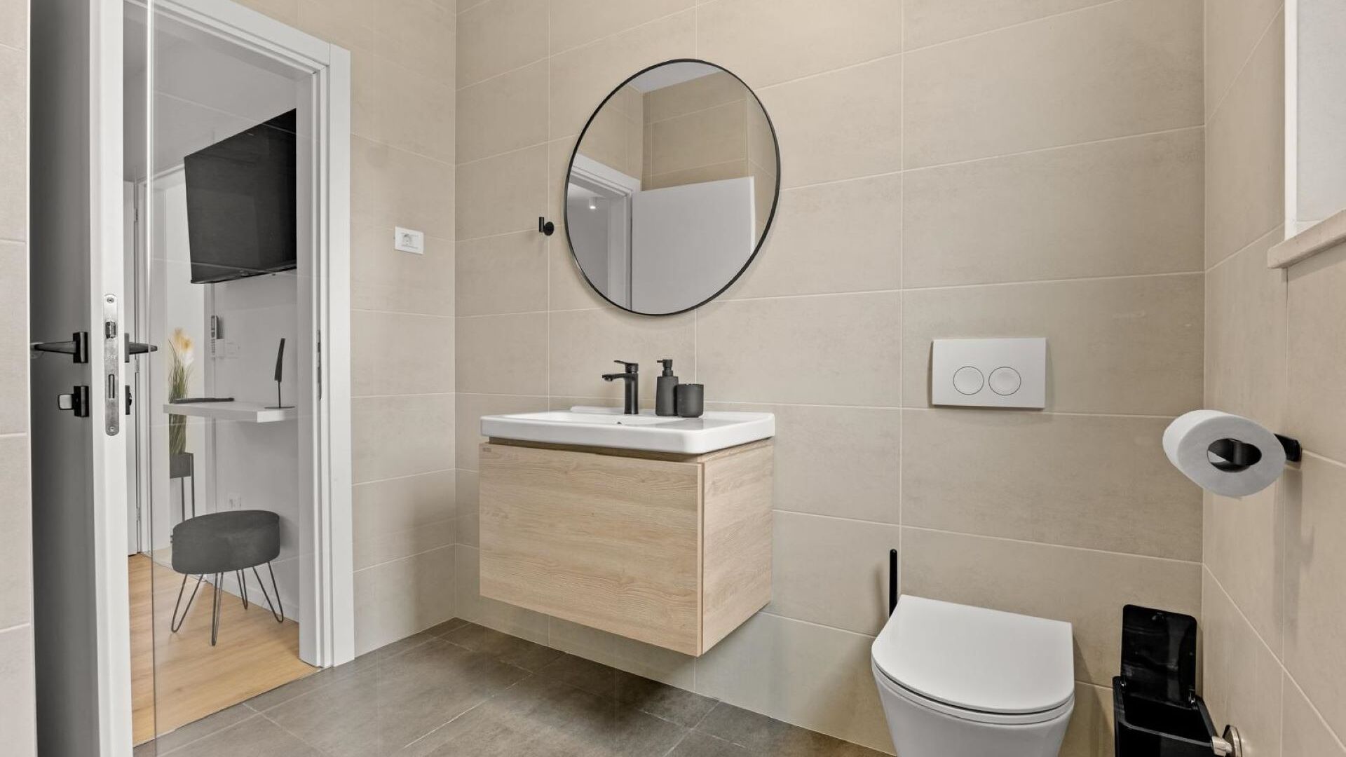 Une salle de bain moderne équipée de toilettes, d’un lavabo, d’un miroir et d’un espace douche.