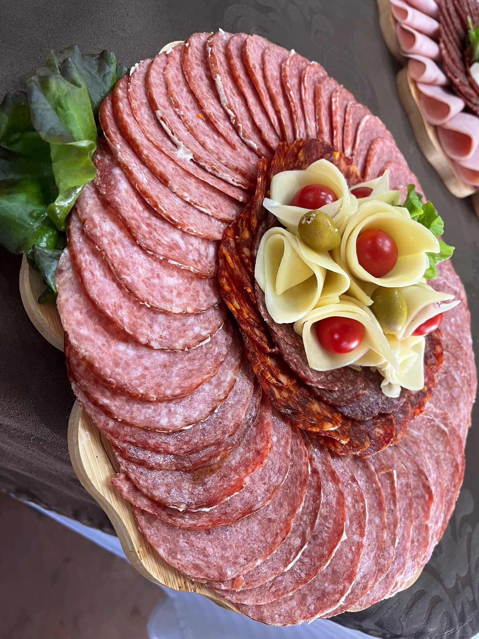 Una tabla de embutidos con fiambres, queso y aceitunas.