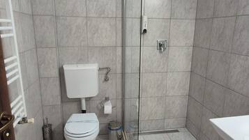 A modern bathroom with a toilet, bidet, and shower.