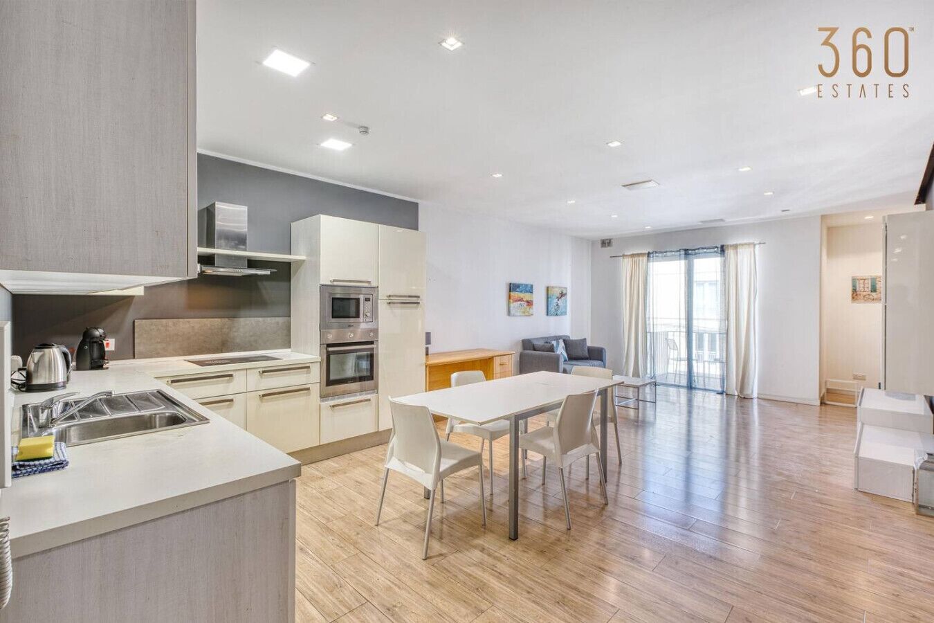 Un appartement moderne comprenant une cuisine, un coin repas et un espace de vie.