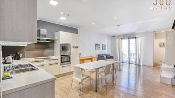 Un appartement moderne comprenant une cuisine, un coin repas et un espace de vie.