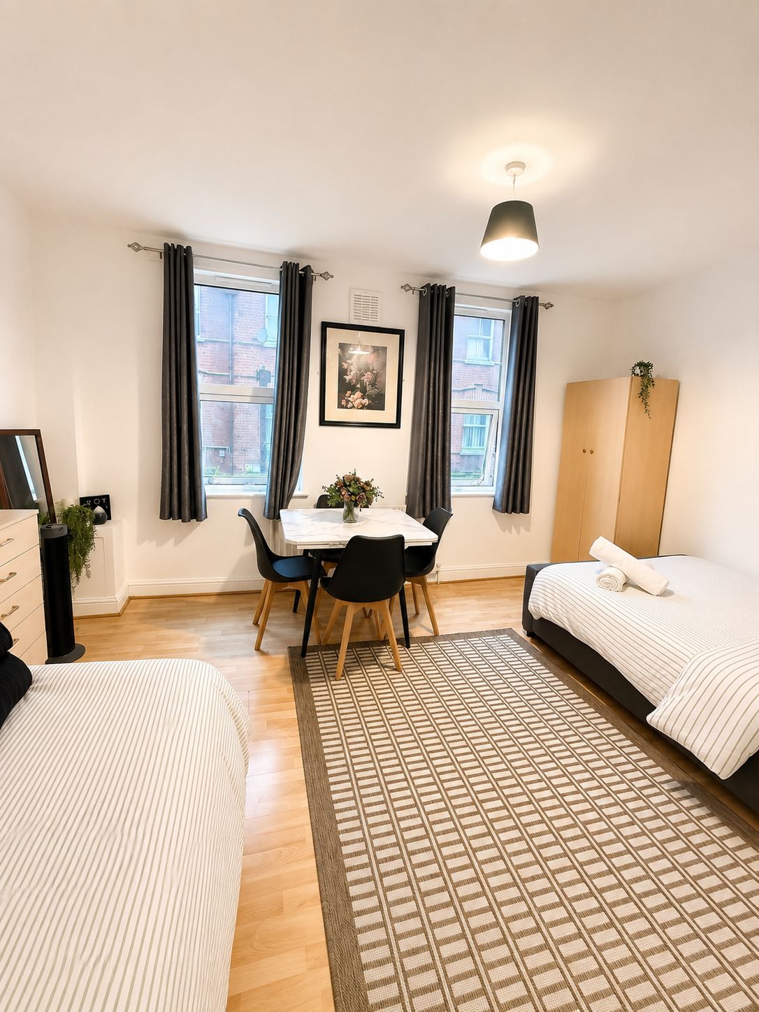 Una habitación de hotel moderna con una cama, un escritorio y una mesa de comedor.