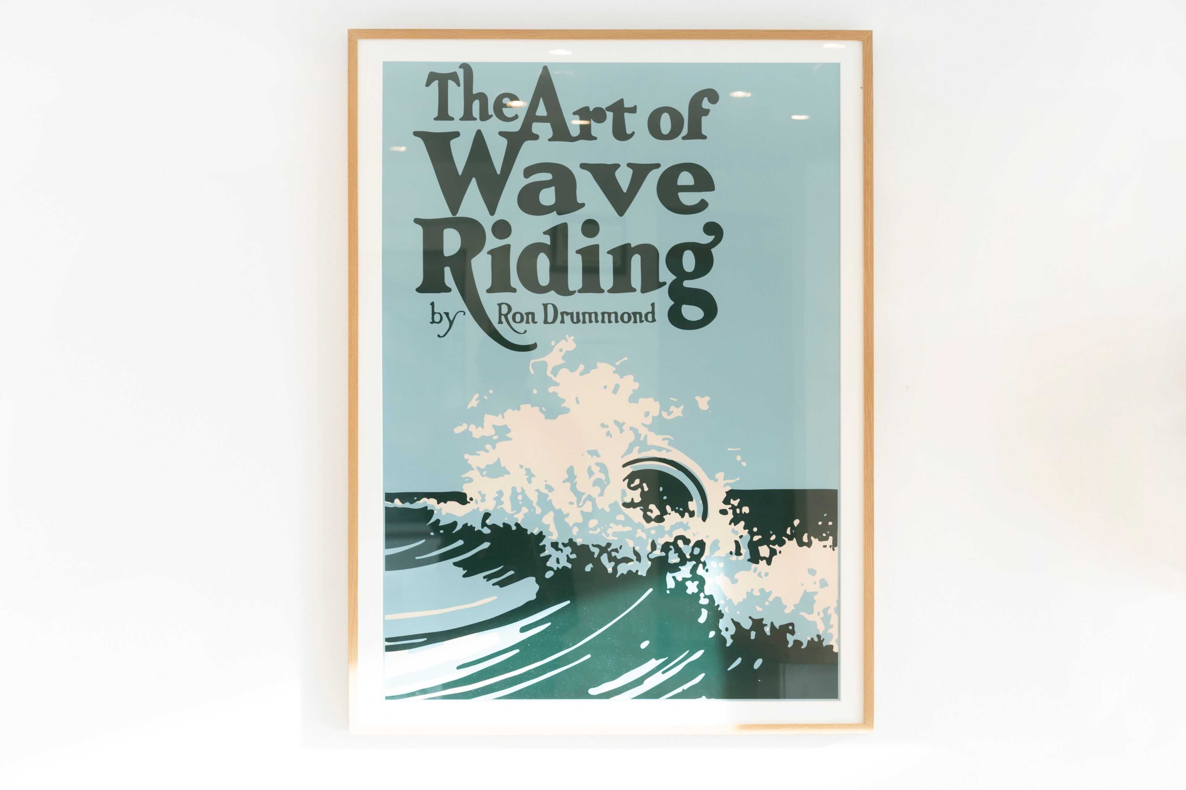 A framed book titled 'The Art of Wave Riding' by Ron Drummond.