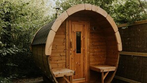 A wooden barrel-shaped structure with a door, a small bench, and a window. - Luxury Holiday Loft in Si-es-an (Balkbrug)
