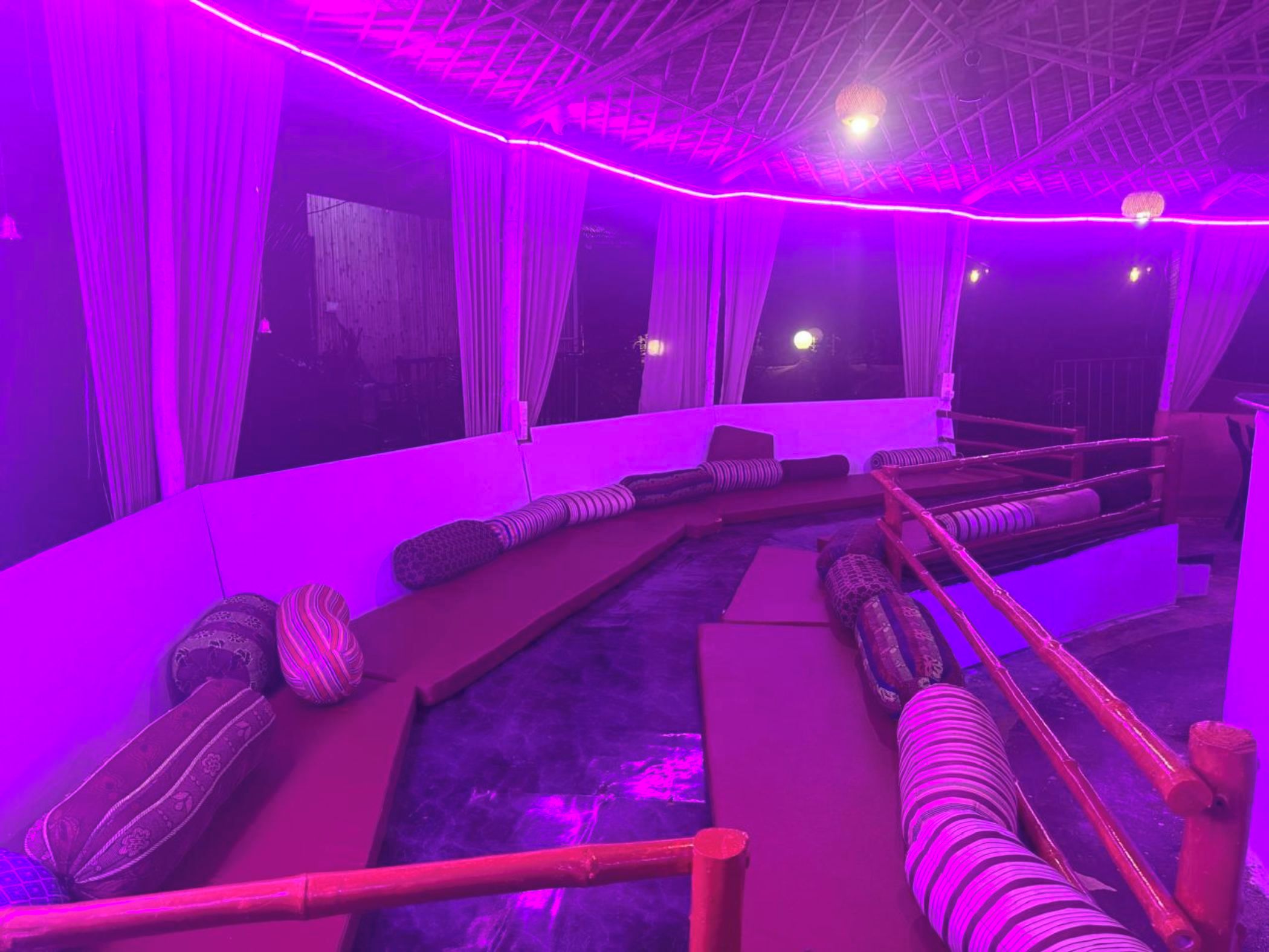 A room with a curved seating area, a small pool, and a ceiling with a grid-like structure.