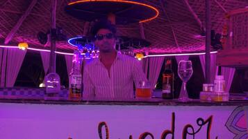 A bar area with a sign reading 'Salvador' and various bottles and glasses on the counter.