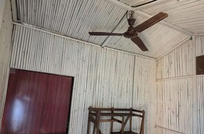 A room with corrugated metal walls, a wooden door, and a ceiling fan. - Wood Castle Arambol (Arambol)
