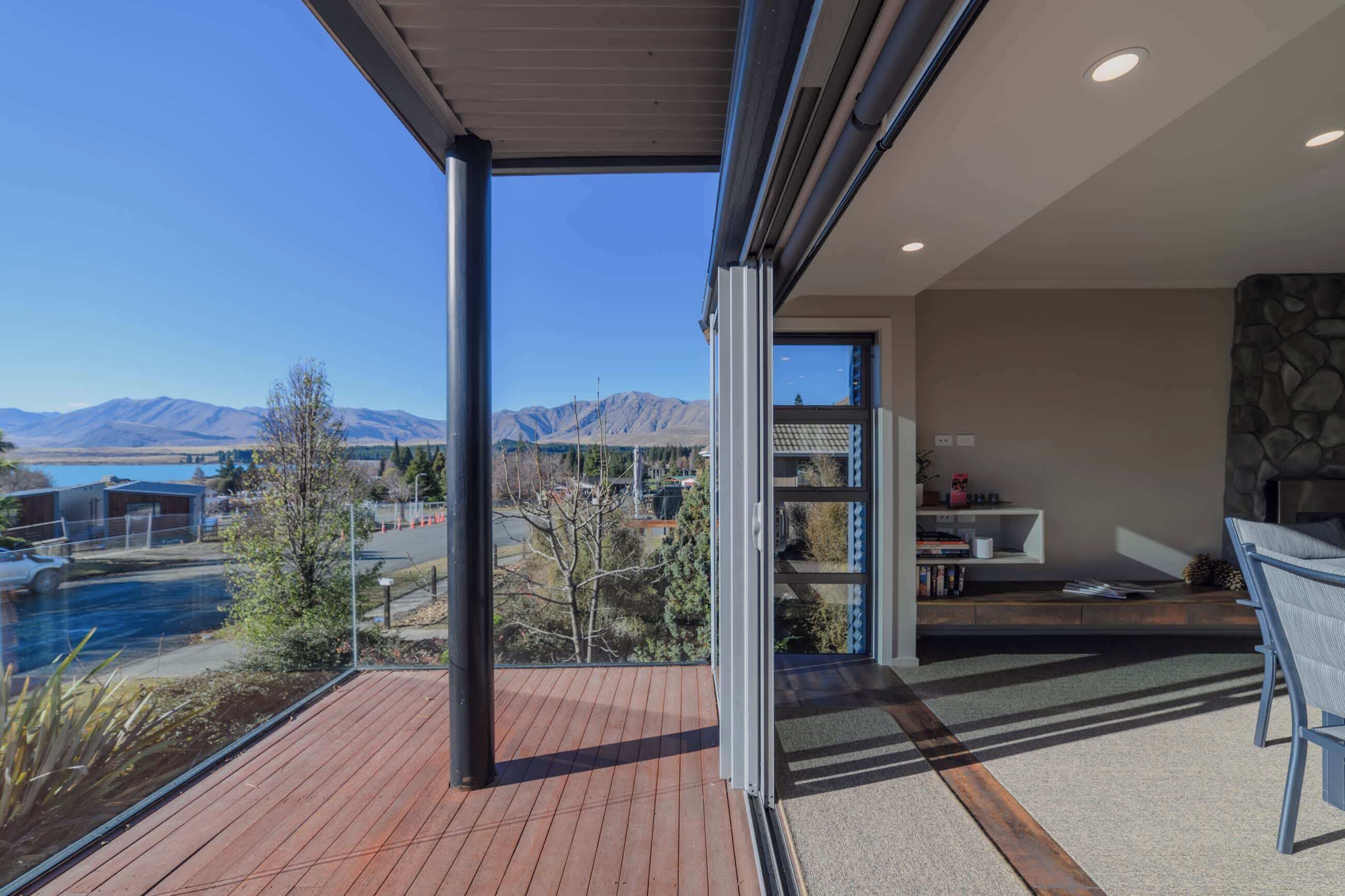 A modern interior with a view of mountains and a pool.