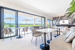 Un comedor moderno con ventanas amplias, sombrillas exteriores y vistas al campo.