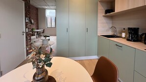 A modern kitchen with light green cabinets, a white countertop, and a coffee machine. - Amazing Apartment in Bree With Terrace (Bons Villers)