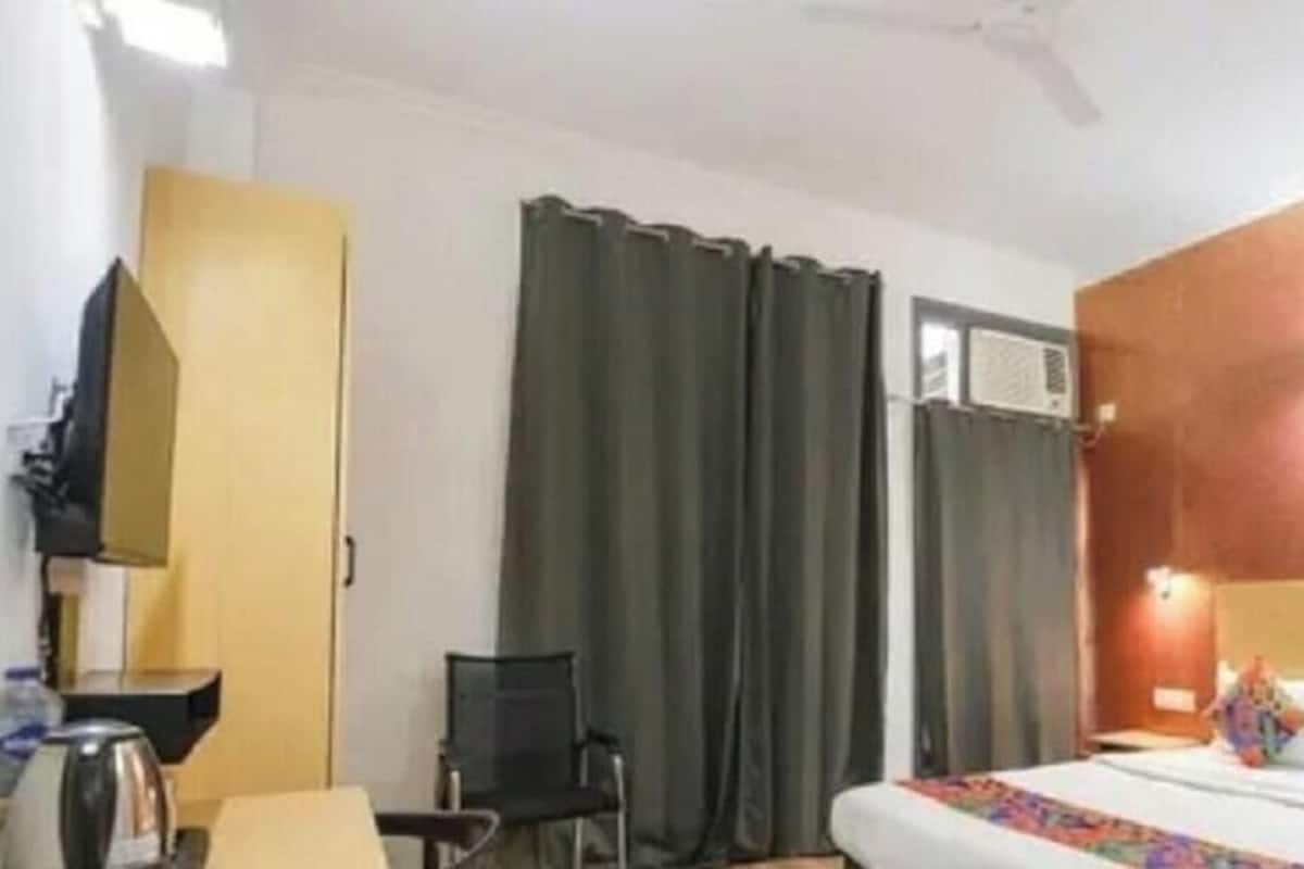 Een hotelkamer met een bed, bureau, stoel en kledingkast.