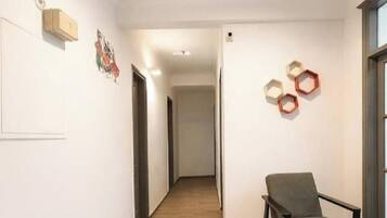 A hallway with a chair, a door, and hexagonal wall decorations.